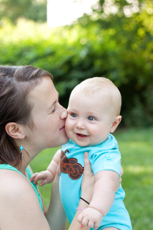 June with smiling blue-eyed baby boy outside at green park