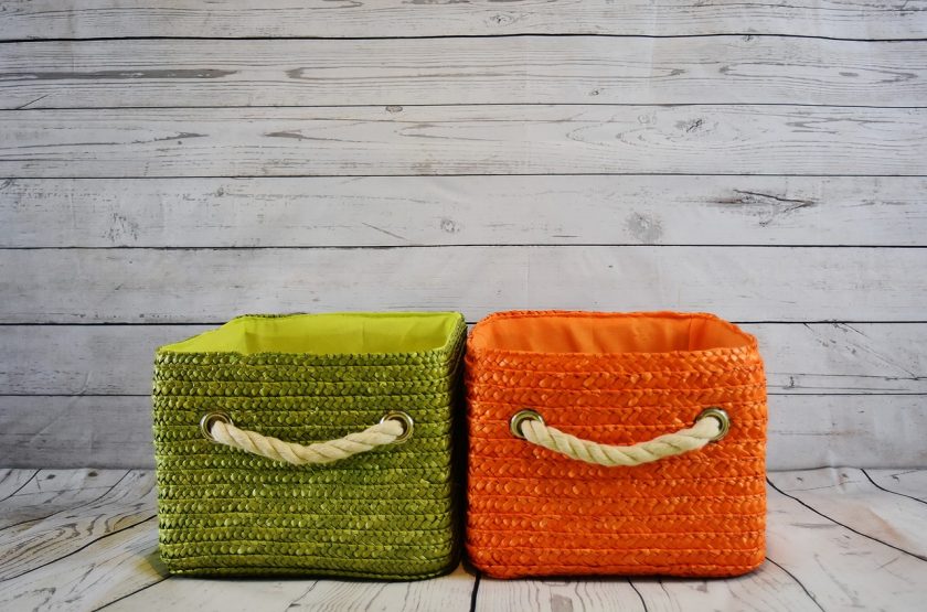 green and orange rope baskets side by side on floor with gray wall