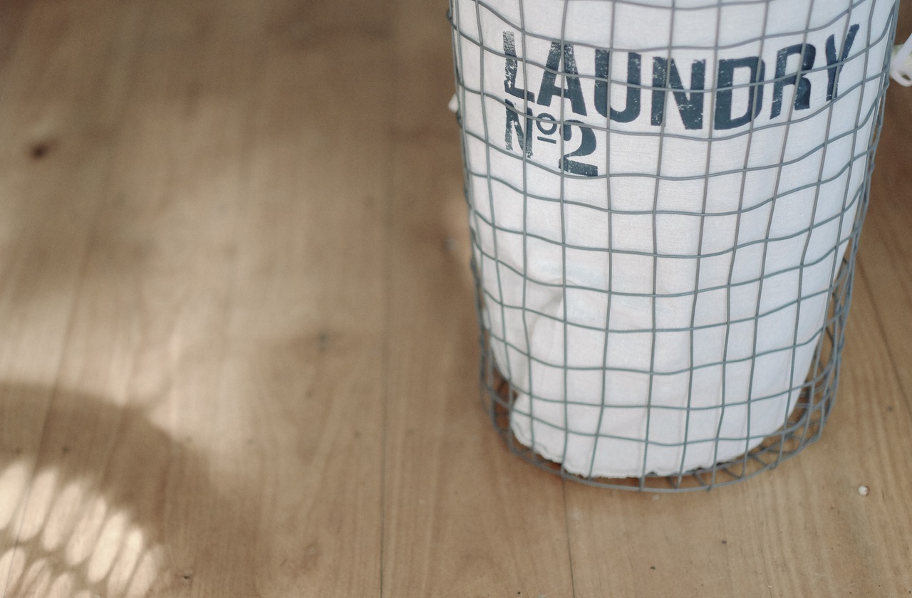 Laundry; The House that Cleans Itself cloth and wire laundry hamper on wooden floor