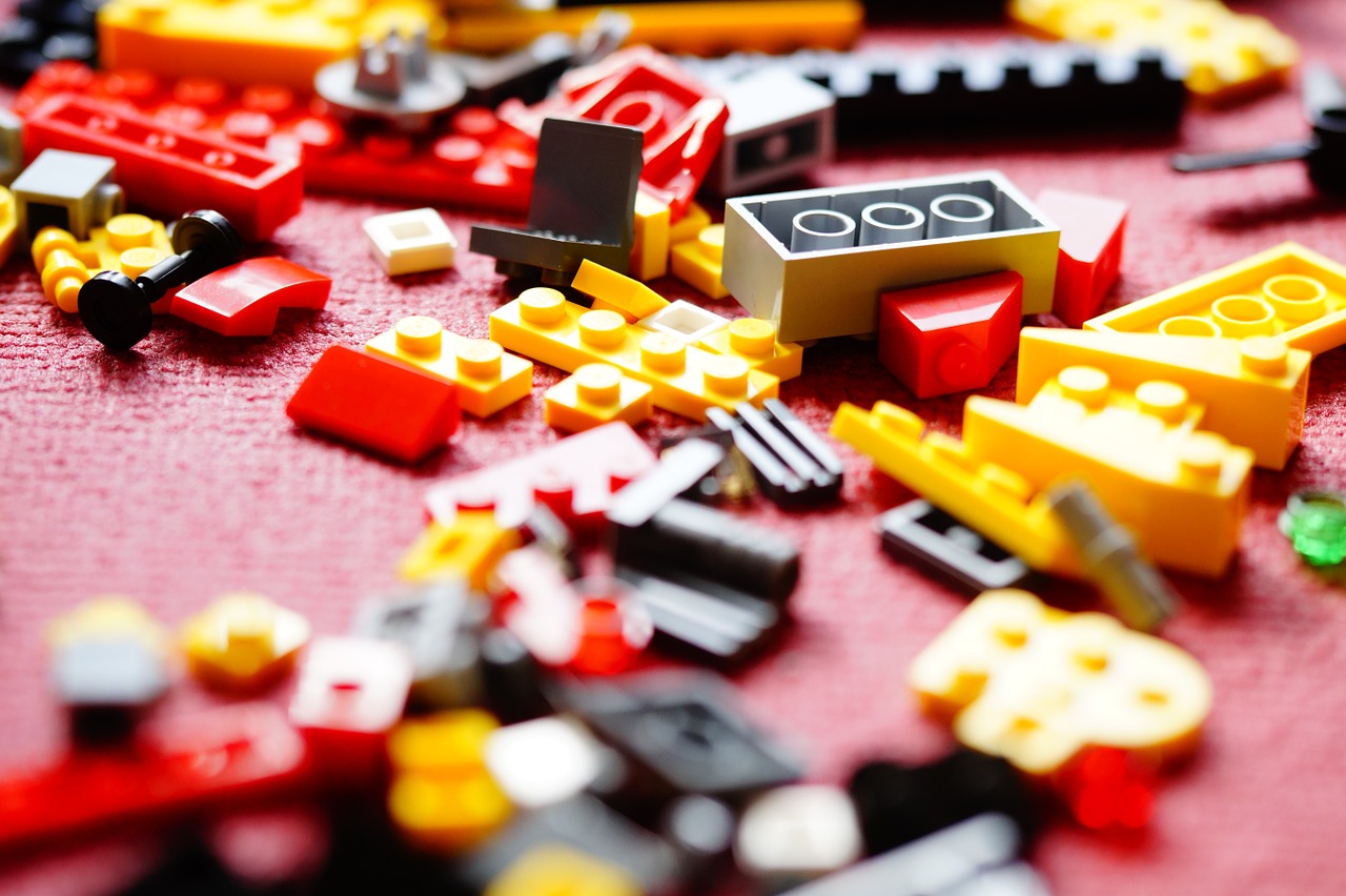 yellow, red, black and gray legos strewn across floor