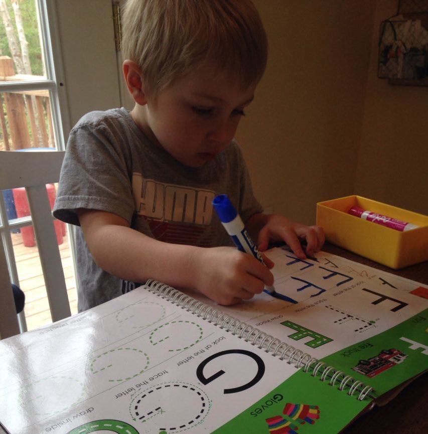 5-year-old tracing the letter "F's" with an expo markers