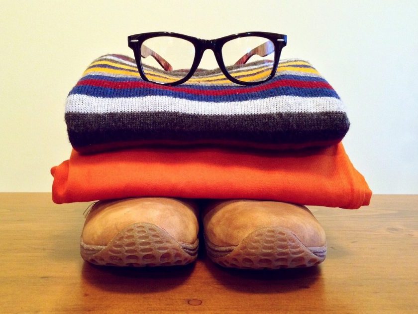stacked capsule wardrobe outfit: brown shoes, orange pants, striped sweater and glasses on top