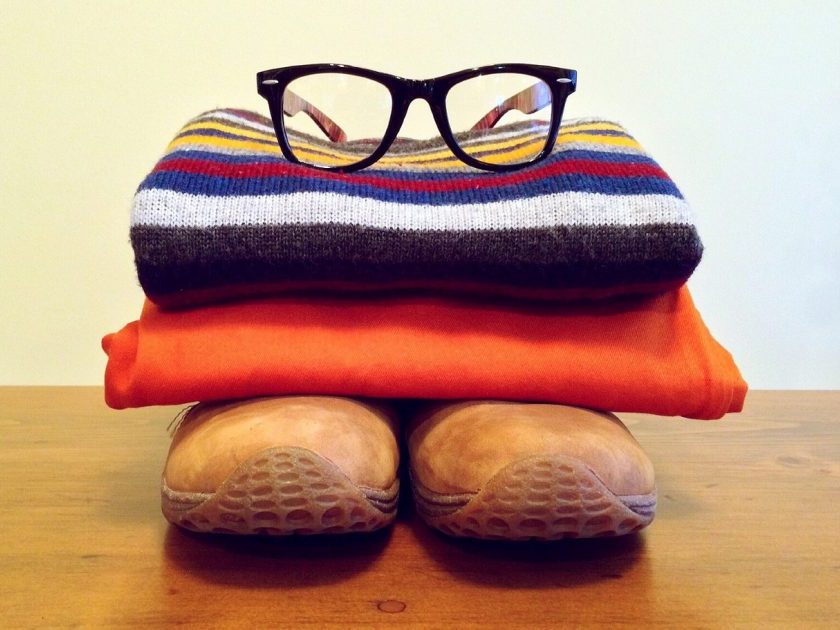stacked capsule wardrobe outfit: brown shoes, orange pants, striped sweater and glasses on top