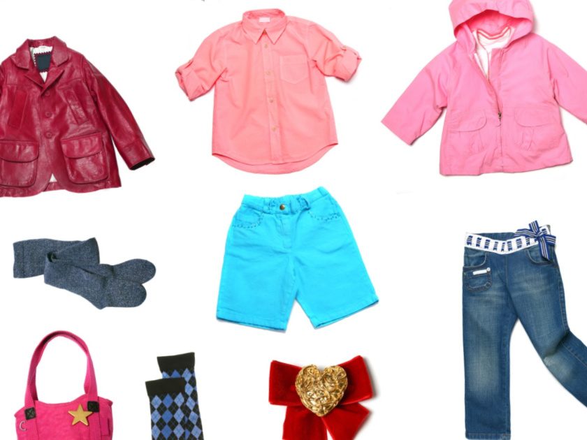 Kids clothes set isolated on white - rain coat, jeans, shorts, purse, etc.