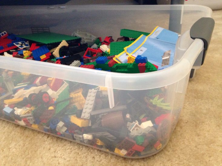 long, shallow, clear storage container full of LEGO bricks