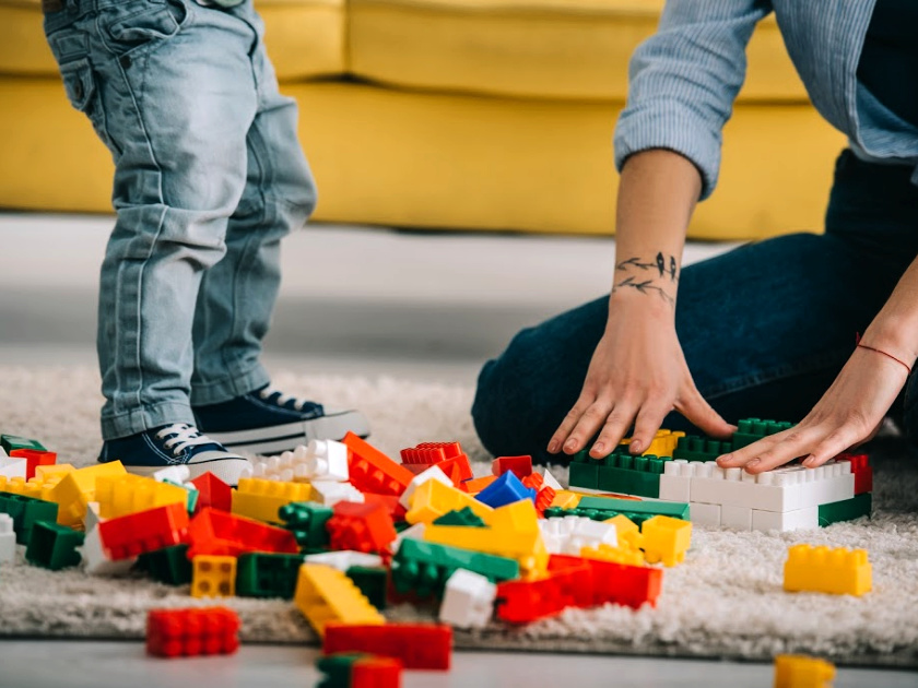 mom and child playing with lego duplo blocks on the floor