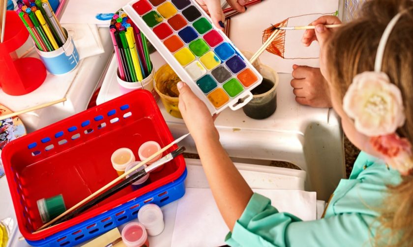 girl creating artwork using watercolor paints