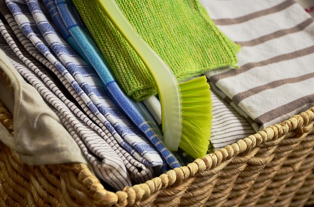 basket full of striped dish cloths and dish brush