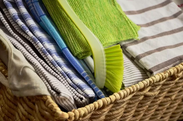 basket full of striped dish cloths and dish brush