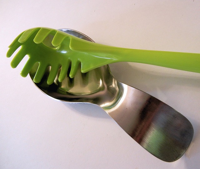 metal spoon rest with green pasta spoon on white countertop
