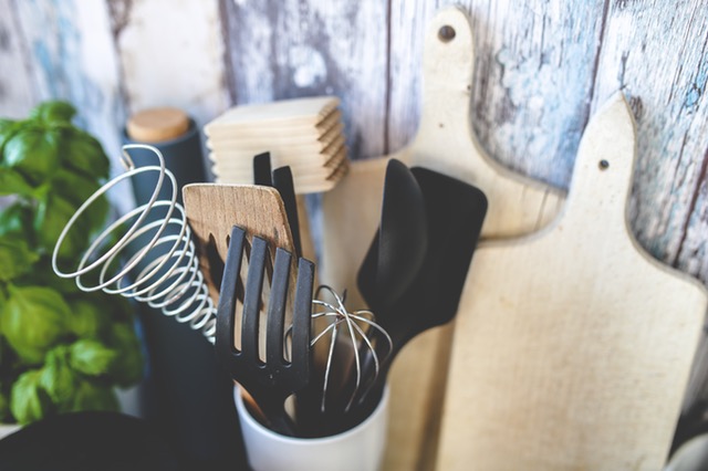 kitchen counter with cutting boards and ceramic vase holding kitchen utensils