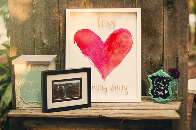 wooden shelf holding pictures, including one with a heart saying love is everything, and other knick-knacks