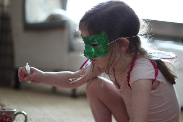 homeschooled child with green mask playing dress up