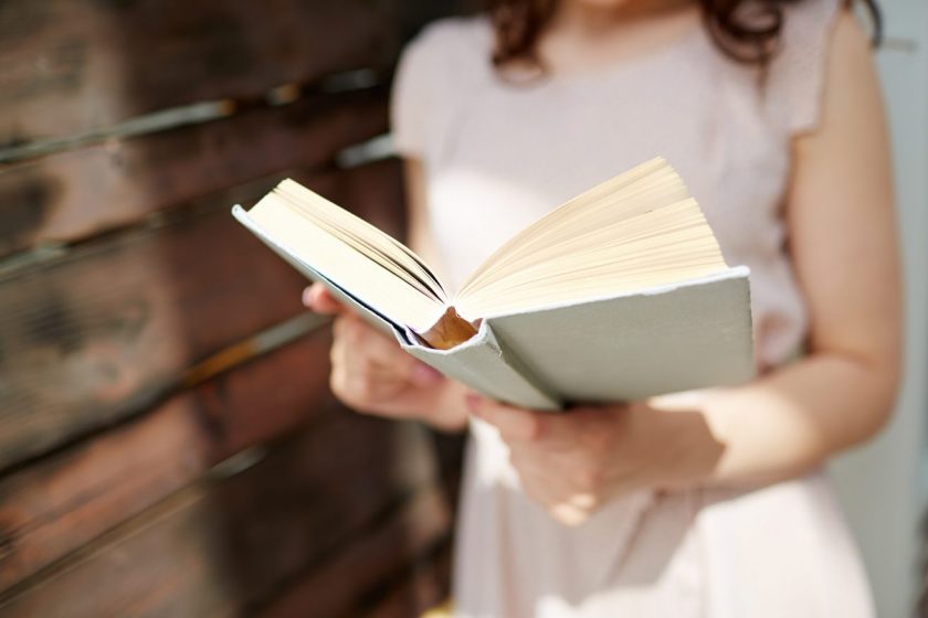 woman holding an unschooling book in her hands, reading
