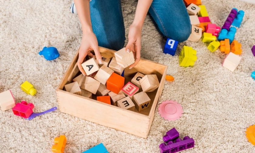 mom picking up alphabet blocks