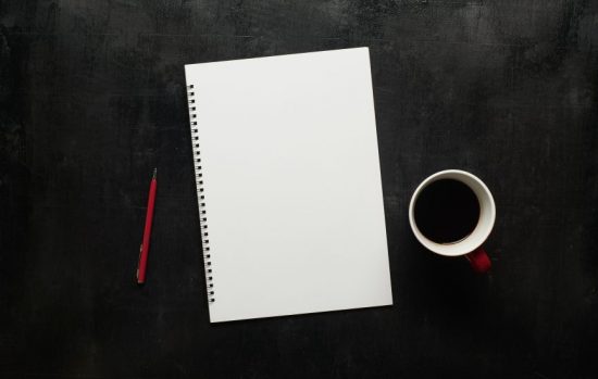 blank notebook, coffee mug and pen on desk