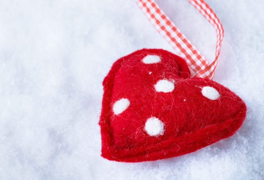 red felt heart ornament with white polka dots on white felt background