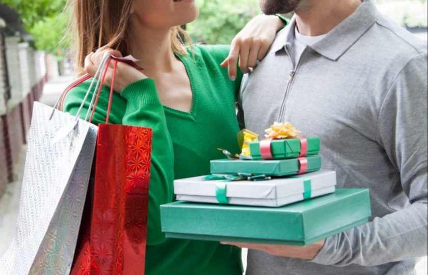 wife and husband christmas shopping for kids, holding presents and shopping bags