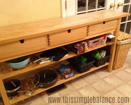 long wooden kitchen shelf with kitchen items on shelves, but nothing on countertop