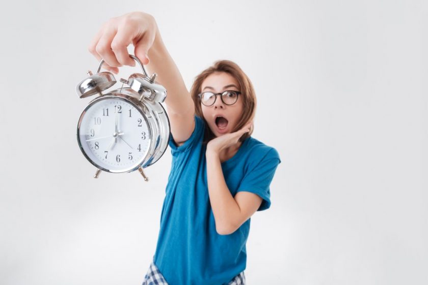 gasping homeschool mom holding up alarm clock, trying to start new homeschool schedule