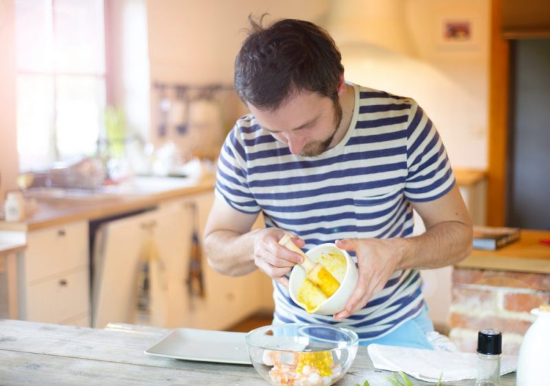 man using mortar and pestle to cook chicken in paperless kitchen