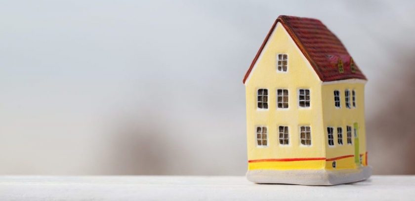 miniature house ornament sitting on white counter, demonstrating small house concept