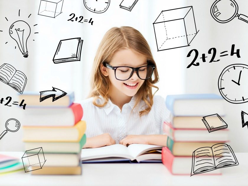 school-aged girl with glasses reading a book, surround by stacks of books and math concepts on the wall behind her