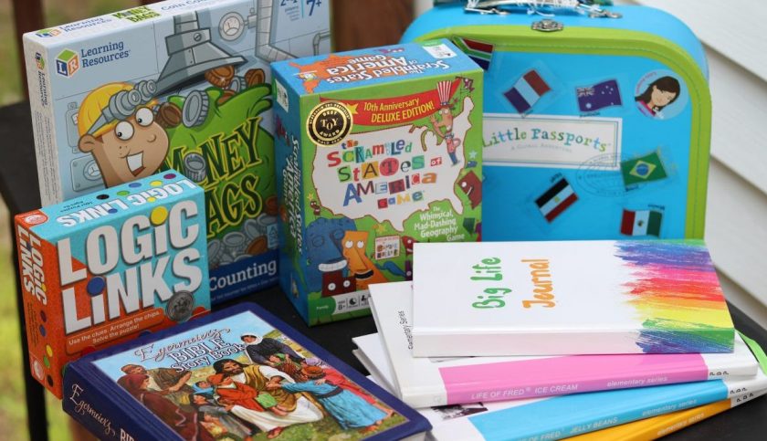 resources for homeschooling third grade - educational board games, stack of books, little passports suitcase