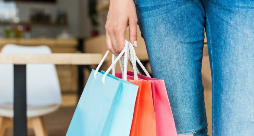 close up on woman holding colorful shopping bags