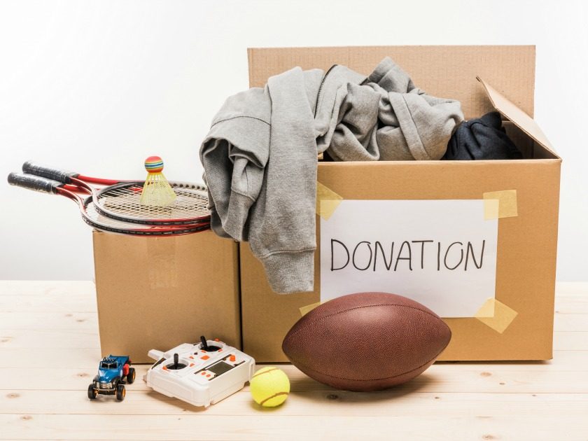 cardboard box marked donation, with decluttered items waiting to be given away