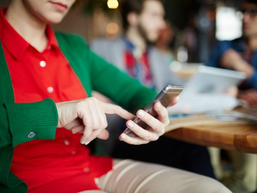 woman looking at phone, wanting to buy things