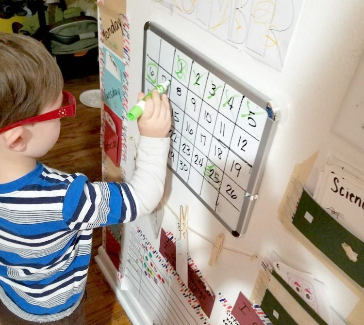 kid friendly command center, child writing on dry erase board calendar