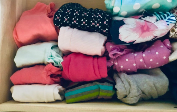 organized baby clothes in drawer