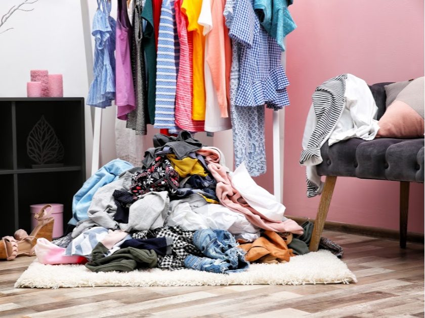 Messy, cluttered dressing room interior with clothes rack