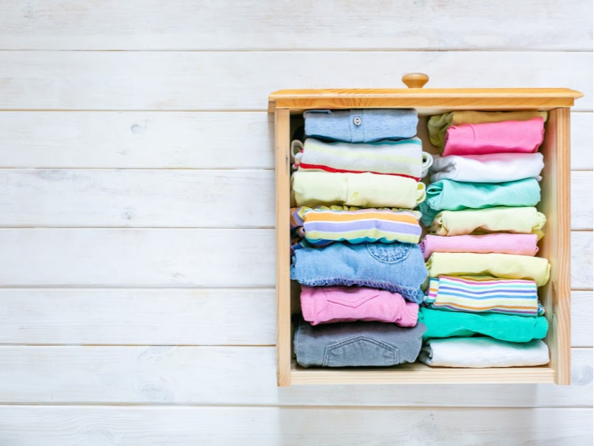 clothes folded using Marie Kondo's folding method, drawer sitting on wood floor