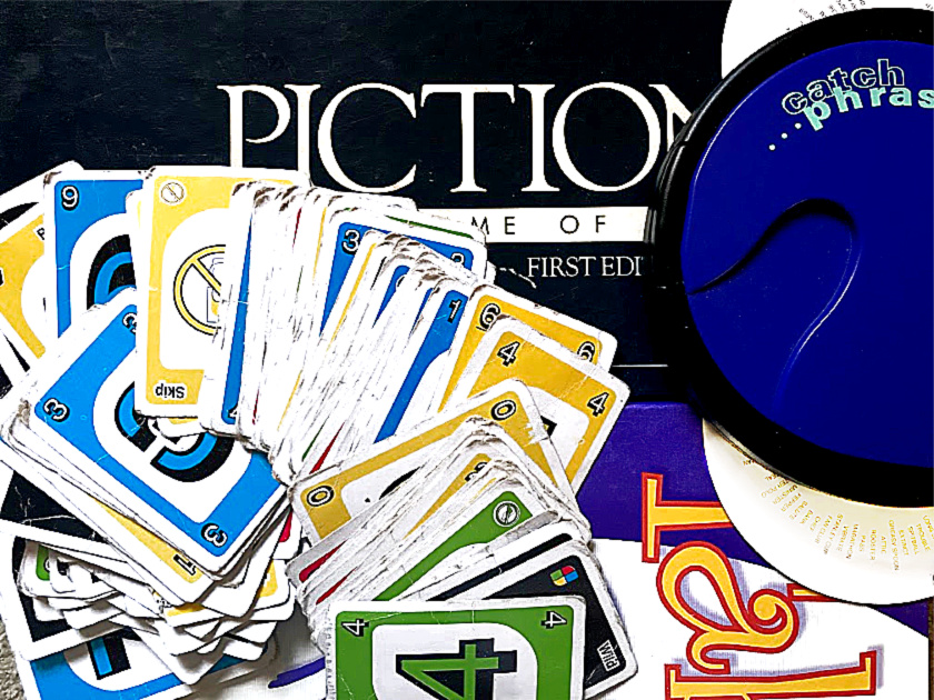 uno cards spread on top of pictionary, taboo and catch phrase games