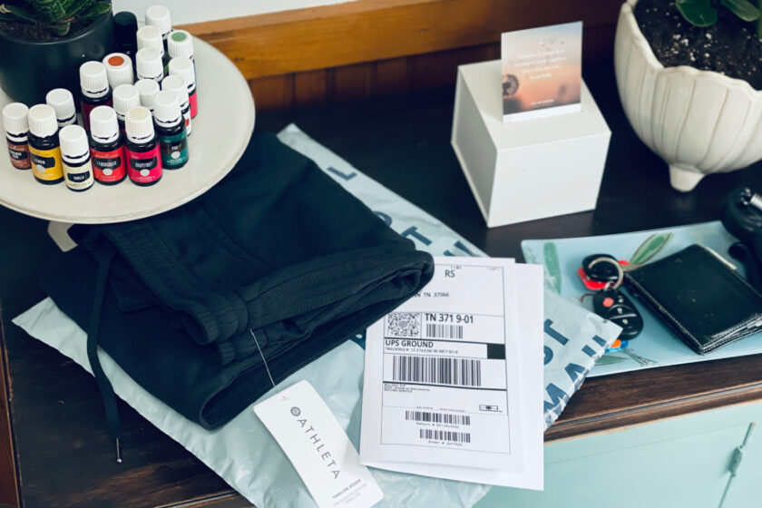 pile of clothing to return, sitting on table of mom trying to make life easier