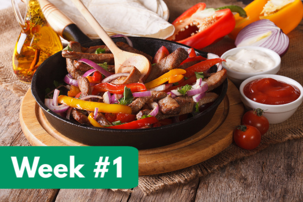 fajita ingredients in cast iron skillet on cutting board, surrounded by toppings with text overlay, "week #1"