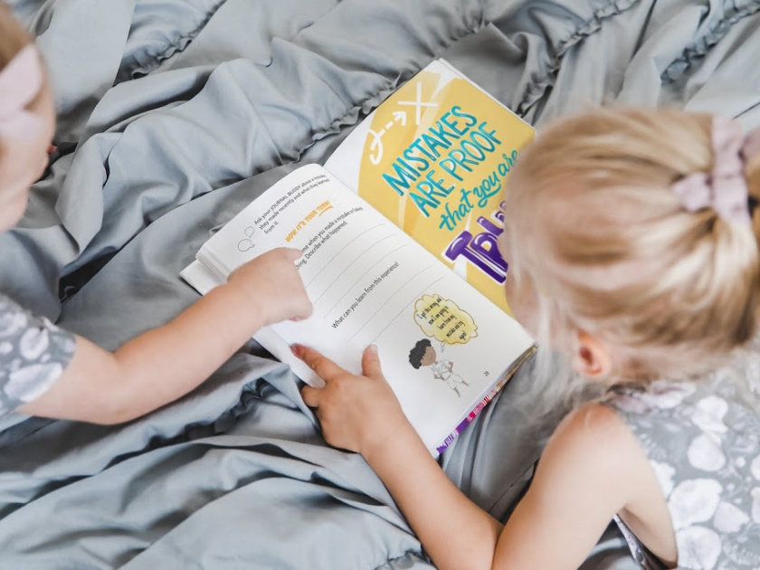 little girl reading Big Life Journal on bed