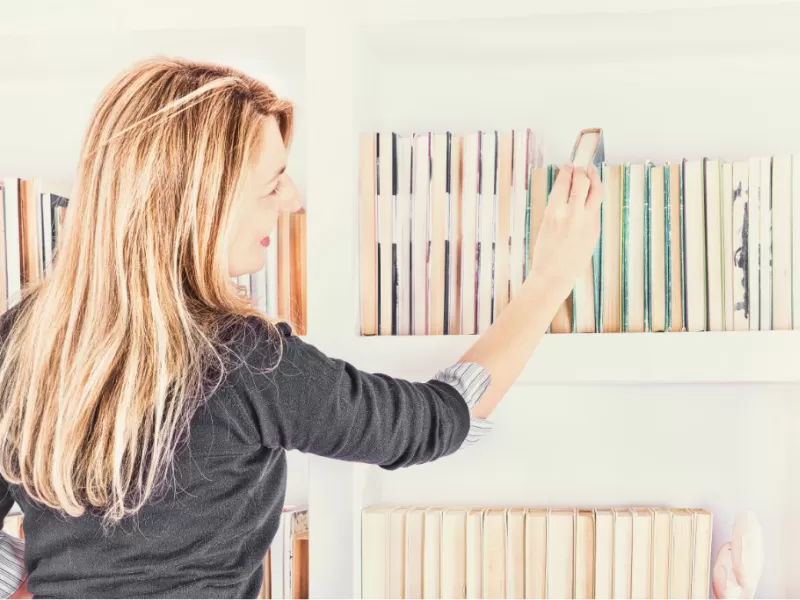 woman selecting books for homeschool year