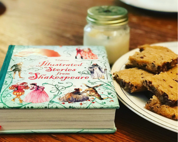 usborne illustrated stories from shakespeare next to plate of blondies with candle