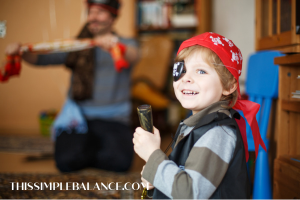 little boy in pirate dress-up clothes with eye patch and bandana