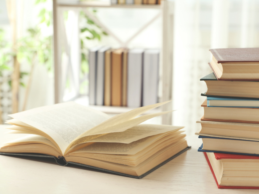 stack of chapter books for reading aloud, sitting on table, with one open in the middle