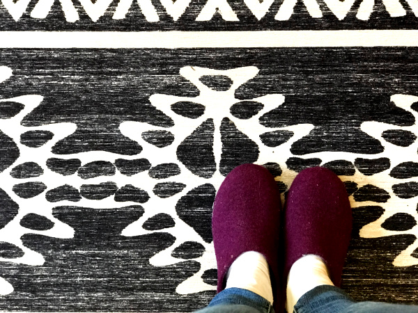 Ruggable black and white patterned rug with burgundy slippers and white socks