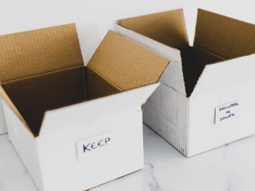 two white cardboard boxes labeled "keep" and "declutter or donate"