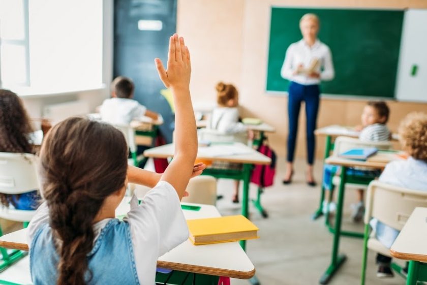 girl raising hand in classroom