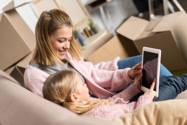 mom and daughter sitting close together looking at ipad