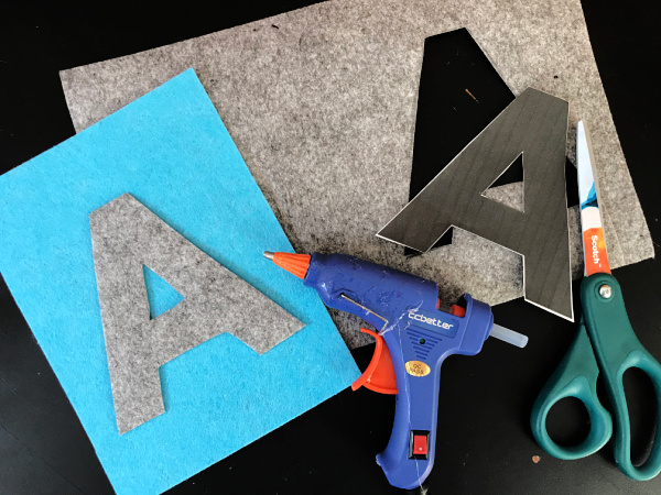 Letter A on felt rectangle part of banner with glue gun and scissors