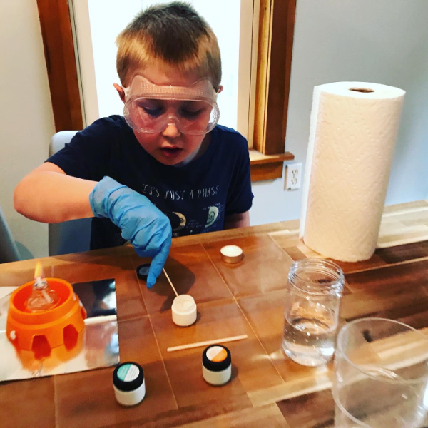 homeschooled child doing science experiment with fire and chemicals