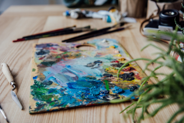 messy easel covered with acrylics on art table